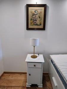 a table with a lamp on it next to a bed at Ferienwohnung RESL - geschmackvoll renoviert & zentral im historischen Schindelhaus in Oberstaufen