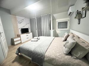 een slaapkamer met een groot bed en een televisie bij Център Варна апартамент in Varna