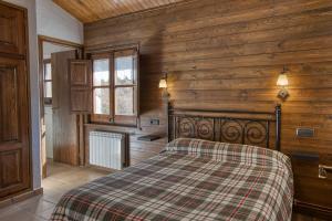 1 dormitorio con 1 cama en una habitación con paredes de madera en Nastura Casa Rural L'Art, en Rupit