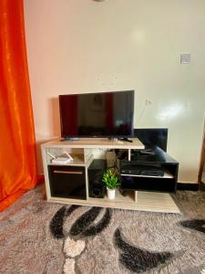 a flat screen tv sitting on a entertainment center at Safari Stays Staycation Homes in Ngong