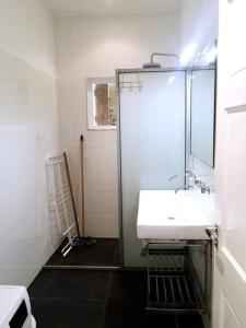 La salle de bains est pourvue d'un lavabo blanc et d'un miroir. dans l'établissement Caribbean Court E1, à Kralendijk