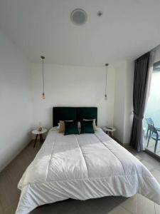 ein Schlafzimmer mit einem großen weißen Bett mit grünen Kissen in der Unterkunft Mejor edificio de Quito Edificio Oh Coliving Ecuador Gonzalez Suarez in Quito