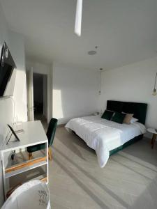 um quarto com uma cama, uma mesa e uma televisão em Mejor edificio de Quito Edificio Oh Coliving Ecuador Gonzalez Suarez em Quito