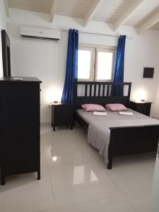 um quarto com uma cama com duas almofadas cor-de-rosa em Caribbean Court E1 em Kralendijk