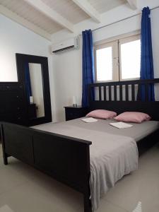 una camera da letto con letto, cuscini rosa e specchio di Caribbean Court E1 a Kralendijk