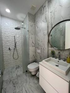 een badkamer met een wastafel, een toilet en een spiegel bij Mejor edificio de Quito Edificio Oh Coliving Ecuador Gonzalez Suarez in Quito
