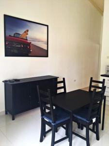 - une table à manger noire avec 2 chaises et une télévision dans l'établissement Caribbean Court E1, à Kralendijk