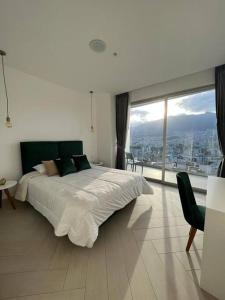 um quarto com uma cama grande e uma janela grande em Mejor edificio de Quito Edificio Oh Coliving Ecuador Gonzalez Suarez em Quito