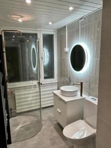 a bathroom with a toilet and a sink and a shower at KIELO - City Apartment Rovaniemi in Rovaniemi
