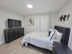 a white bedroom with a bed and a dresser at Room for rent with own bathroom in Hartford
