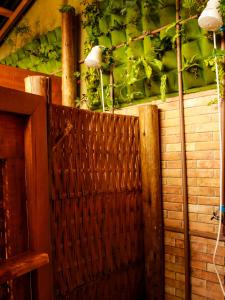 un portail en bois avec des plantes sur un mur dans l'établissement Valhalla Glamping House, à Bombinhas