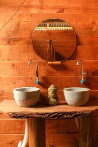 2 lavabos en una mesa de madera con un espejo en Valhalla Glamping House, en Bombinhas