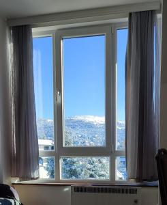 ein Fenster in einem Zimmer mit Aussicht in der Unterkunft Apartman Standard Lux u Kraljevim Čardacima in Kopaonik
