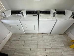 three washing machines in a room with a floor at Motel 6-Cedar Rapids, IA in Cedar Rapids