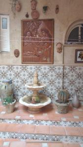 a fountain in the middle of a room with plants at Dar Nana in Sousse