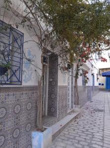 un árbol al lado de un edificio en Dar Nana, en Sousse