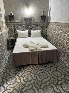 a bedroom with a large bed with a tiled floor at Dar Nana in Sousse