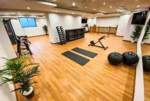 a gym with a hard wood floor and a room with yoga mats at Studio Khalifa canal view in Dubai