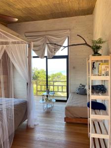 sypialnia z łóżkiem i balkonem w obiekcie Eco Boutique B&B w mieście Punta del Diablo