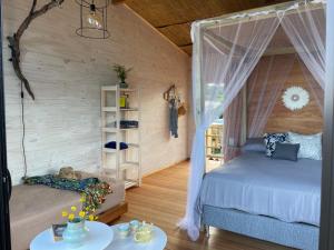 sypialnia z łóżkiem i stołem w pokoju w obiekcie Eco Boutique B&B w mieście Punta del Diablo