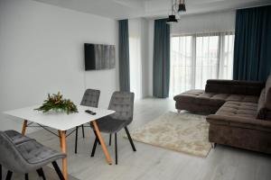 a living room with a couch and a table and chairs at Apartament Eva in Cristian