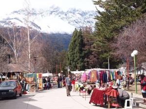 a group of people walking down a street with a market at Departamentos Lina in El Bolsón
