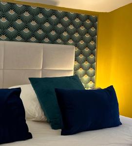 1 dormitorio con 1 cama con 2 almohadas y cabecero en Appart' Studio cooconing - Champs Elysées - JO 2024, en Maisons-Laffitte