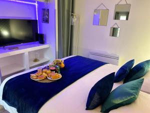 ein Schlafzimmer mit einem Bett und einem Tablett mit Essen drauf in der Unterkunft Appart' Studio cooconing - Champs Elysées - JO 2024 in Maisons-Laffitte