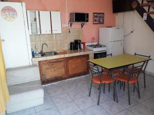 a kitchen with a table and chairs and a refrigerator at Departamentos Lina in El Bolsón