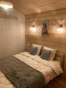 - un grand lit dans une chambre dotée de murs en bois dans l'établissement Maison Boutxy Le Clos des Ours, à Matemale