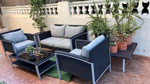 un patio con divano, sedie e tavolo di PLAYA ALMARDA CORINTO, PISCINA, WIFI,2 TERRAZAS, BARBACOA,TRANQUILo a Sagunto