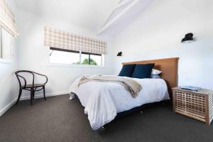 a bedroom with a bed and a chair and a window at The Bungalow Cottage in Young