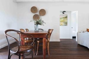 a dining room table with chairs and a vase with flowers at The Bungalow Cottage in Young