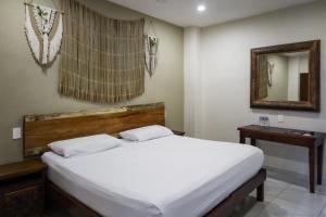 Una cama o camas en una habitación de Hostal Tunich Naj & Hotel
