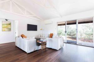 a living room with two white couches and a table at The Bungalow Cottage in Young