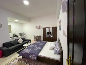 a bedroom with a bed and a couch in a room at Karen's Studio in corniche Abu Dhabi behind Shikha Fatima park in Abu Dhabi