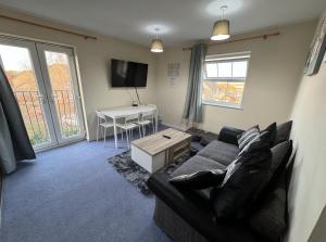 a living room with a couch and a table at Modern Penthouse - 2 Bed, 2 Bath, 2 Gated Parking in Wellingborough