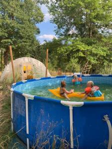 3 bambini che giocano in una piscina in un parco acquatico di Luxe tent Coq de Marans 