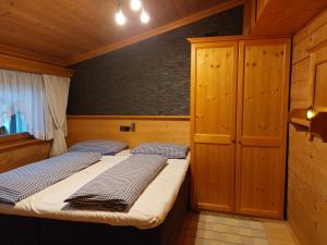 Habitación pequeña con 2 camas y paredes de madera. en Appartement Hödlmoser en Altenmarkt im Pongau