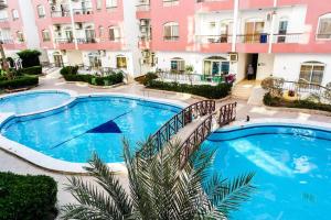 una gran piscina frente a un edificio en Desert Pearl Romantic Apartment, en Hurghada
