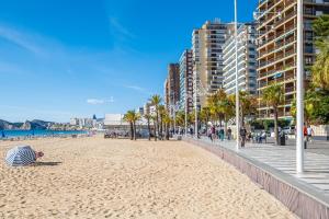 a beach with a person laying on the sand at Bacana 3-3 Apartment Levante Beach in Benidorm