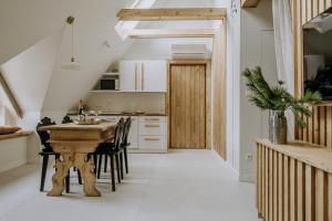a kitchen with a wooden table and chairs at Zakątek Krupówki - Apartamenty w Centrum in Zakopane