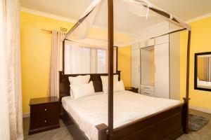 um quarto com uma cama de dossel e um espelho em Misty BnB em Lilongwe