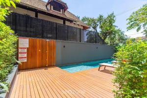 une terrasse en bois avec un banc à côté d'une piscine dans l'établissement Lindo apto 1 quarto em Joinville-SC MSE0302, à Joinville