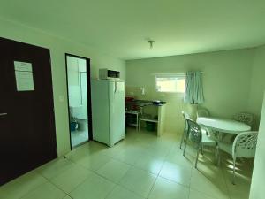een kleine keuken met een tafel en een koelkast bij Divinos Flat Carneiros in Praia dos Carneiros