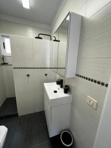uma casa de banho branca com um lavatório e um espelho em Casa Fabulosa Las Floritas- Penthouse em Arona