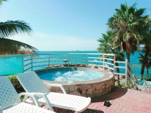 een hot tub met stoelen en de oceaan op de achtergrond bij Departamento al pie del mar Torre Marina in Salinas