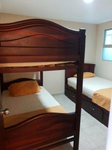 2 slaapplaatsen in een stapelbed in een kleine kamer met 3 stapelbedden bij Departamento al pie del mar Torre Marina in Salinas