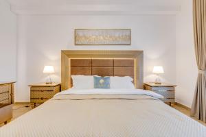 a bedroom with a large white bed with two lamps at GLOBALSTAY. Luxury 3 Bedroom + Maid Townhouse with Sea View in Dubai