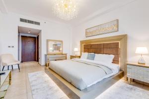 a bedroom with a large bed and a chandelier at GLOBALSTAY. Luxury 3 Bedroom + Maid Townhouse with Sea View in Dubai
